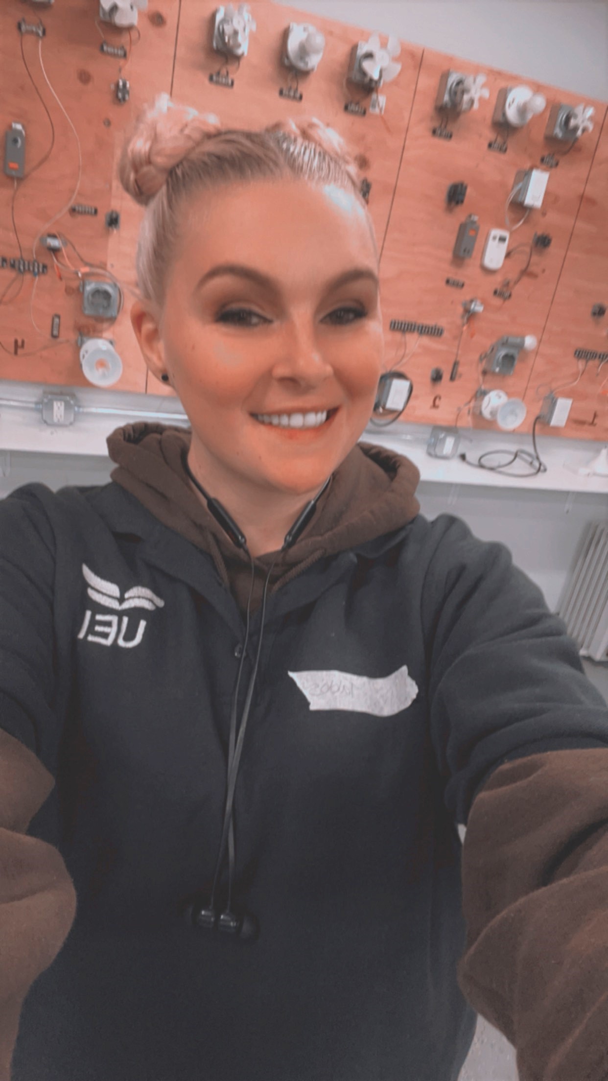 woman in a blue UEI uniform standing in the HVAC lab